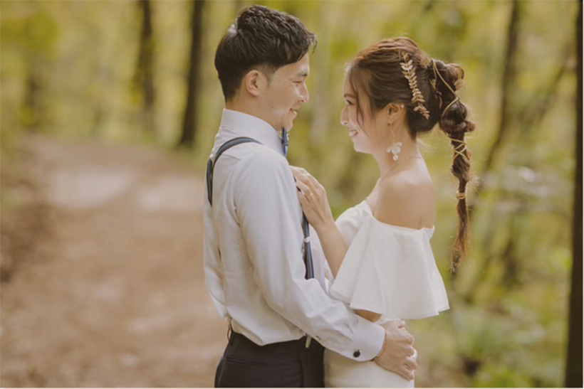 森の中で抱き合う花嫁と花婿